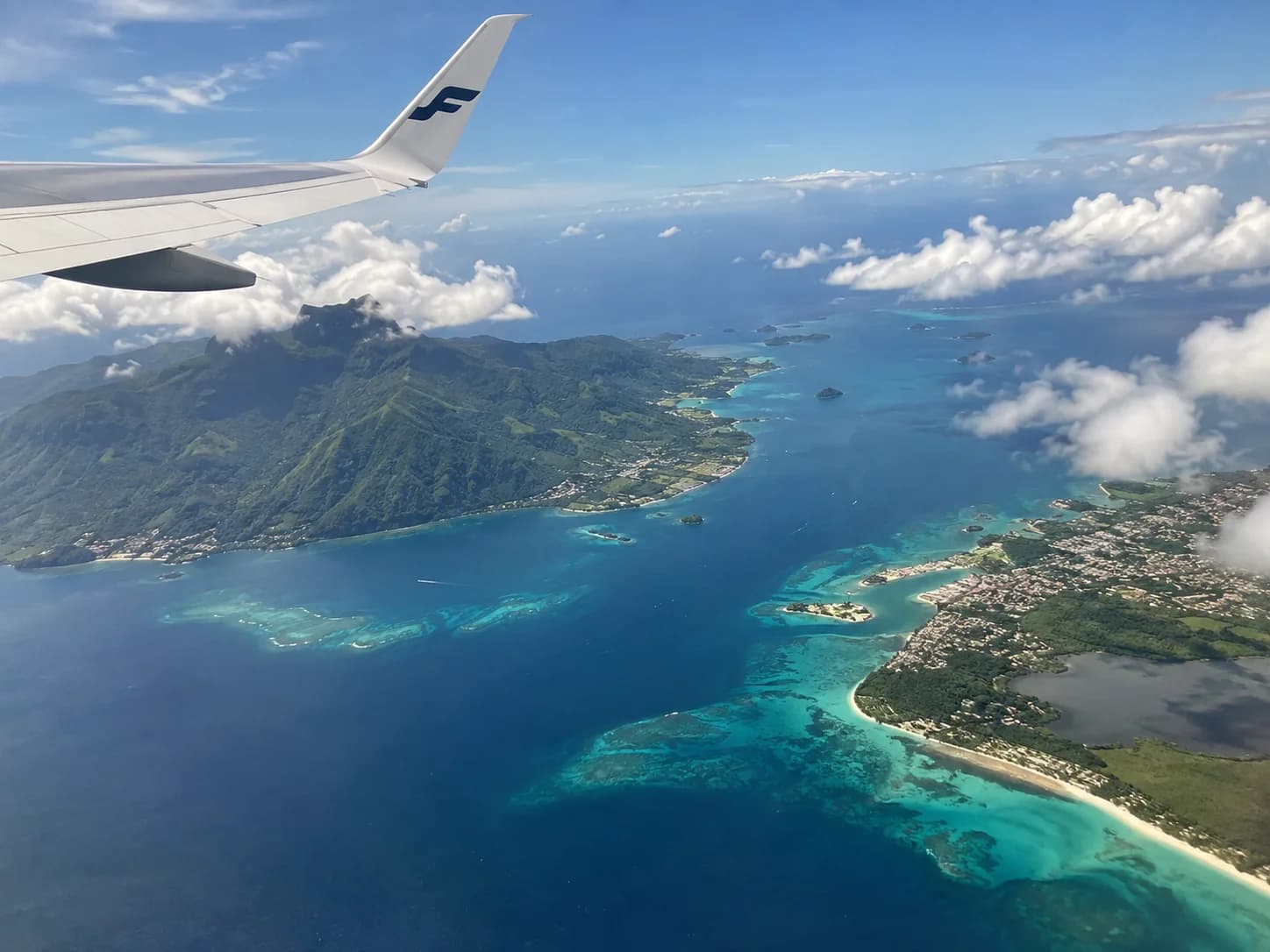 Aile d’avion au-dessus d’îles et d’une mer turquoise, image d’illustration